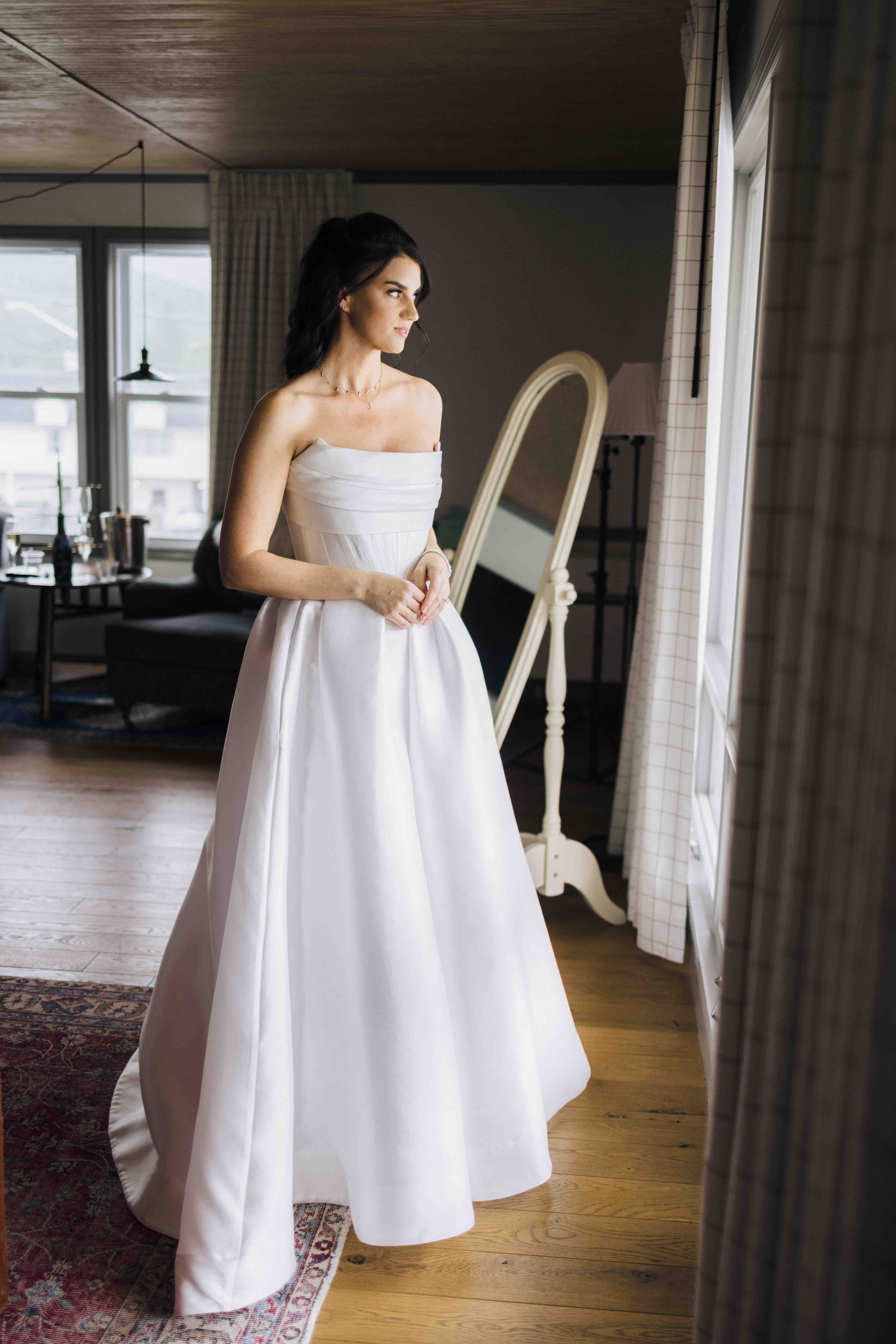 A flat lay photo of wedding invitations, rings, and flowers